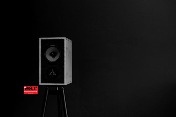 Speaker on a stand with 'ear' logo in the corner against a black background